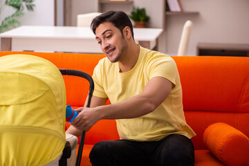 Young man looking after new born at home