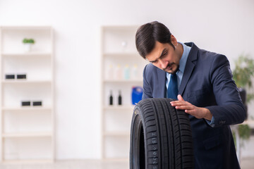 Young man selling tires in the office
