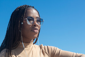 Portrait of beautiful young black woman with blue sky background.