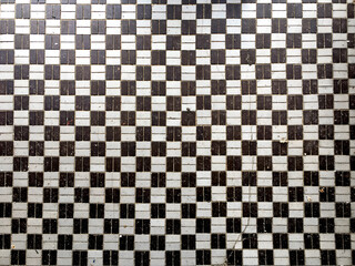 Black and White checkered pattern made of small tiles form the entry of an old store front circa 1920
