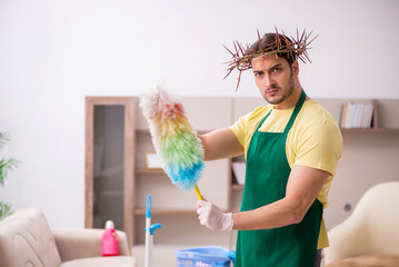 Young male contractor wearing prickly wreath on head cleaning th