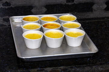 Traditional Creme brulee , crème brûlée ,creme brule, in white ramekins on a tray, in selective focus.