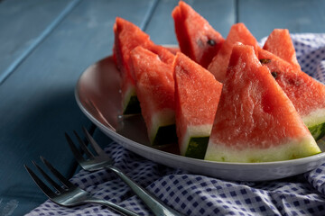 Sliced watermelon. Slices on rustic blue table. Copy space.