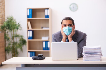 Young male employee wearing mask during pandemic