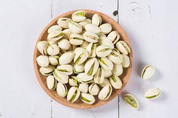 pistachio nuts on white wood background