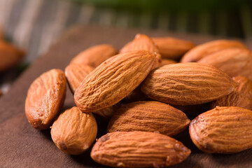 Delicious roasted sweet almonds nuts on wood background