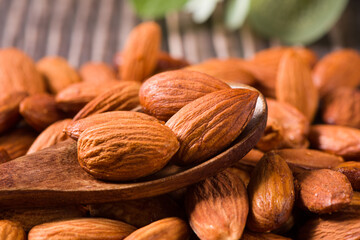 Delicious roasted sweet almonds nuts on wood background