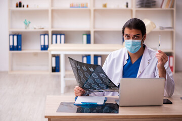 Young male doctor radiologist wearing face-mask during pandemic