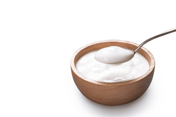 Bowl of yogurt and spoon on white