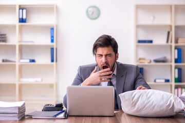 Young male employee in oversleeping concept