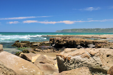 Waves crashing onto the rocky shoreline at Dudley Beach New South Wales Australia