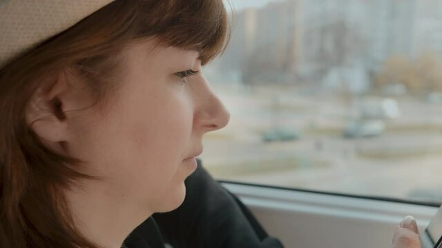 woman near the window uses the phone, scrolls through the news feed, cinematic shot