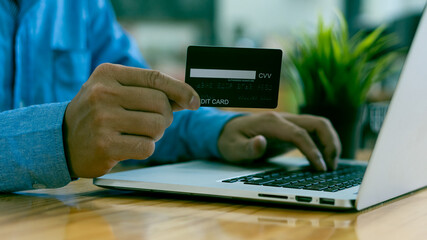 Businessman holding credit card to buy online bill on computer A contactless person pays in a restaurant or grocery store. Smart payment concept, individual bank, at home