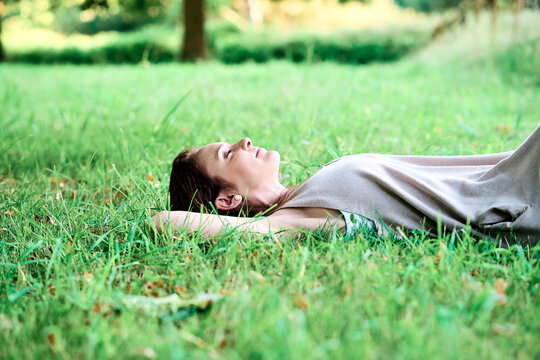 young adult woman lying on the grass on vacation calm relaxed breathing fresh air