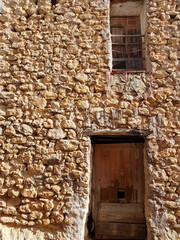 Fototapeta na wymiar Wall of rocks with two old doors.