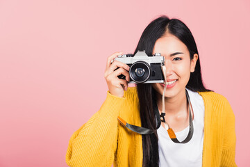 woman smiling photographer taking a picture and looking viewfinder on retro vintage photo camera