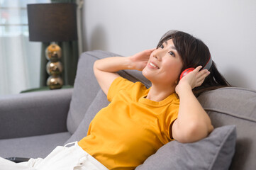 Young happy woman listening to music and relaxing at home