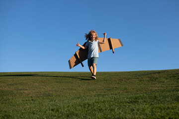 Child boy jumping and running with toy airplane wings. Dream of becoming a pilot. Superhero flying.