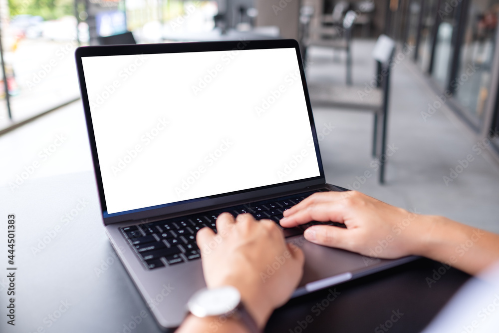 Wall mural mockup image of a woman using and typing on laptop computer with blank white desktop screen in cafe