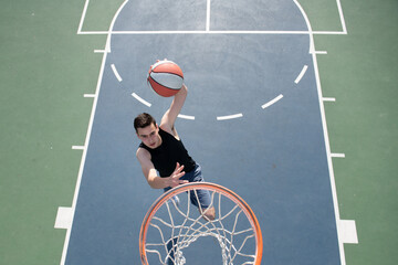 Angle view of man playing basketball, above hoop of man shooting basketball.