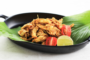 Ayam Sisit or Ayam Suwir is a Balinese Cuisine Made from Spicy Chunks of Chicken Meat, Served on Black Plate.