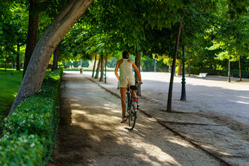 Fototapeta na wymiar Retiro Park in Madrid on a summer day at sunrise with people doing sports on bicycles.
