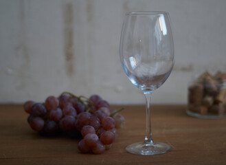 racimo de uva acompañada de una copa conteniendo corchos