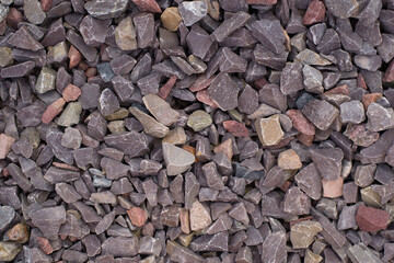 Marble chocolate stone chips, top view. Stone textured background, decorative brown crushed stone for garden decoration.