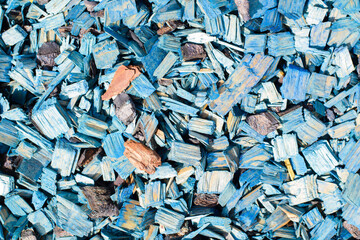 Blue decorative chips, wood textured background top view. Shredded tree bark for decorating a garden plot and other surfaces, close-up