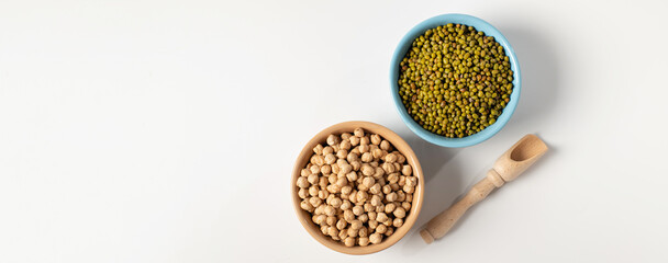 dry chickpeas, green mung bean, in a ceramic dish on a white table, top view, empty space for text