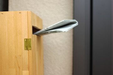 玄関横の木製のポストに投函された英字新聞