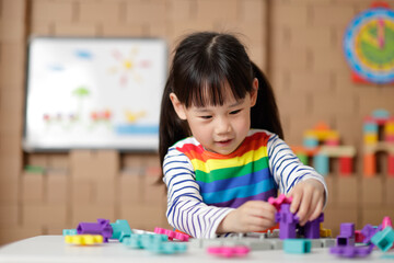 young girl playing gear toy blocks at home