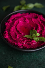 Humus Bowl. Red beetroot hummus with fresh vegetables, olive oil on table