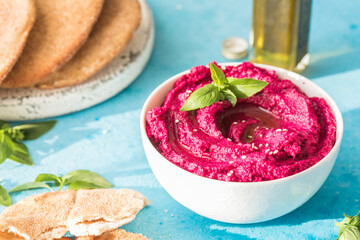 Humus Bowl. Red beetroot hummus with fresh vegetables, olive oil on table