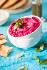 Humus Bowl. Red beetroot hummus with fresh vegetables, olive oil on table
