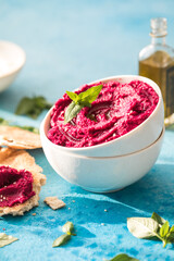 Humus Bowl. Red beetroot hummus with fresh vegetables, olive oil on table