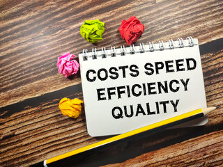 Fototapeta premium Business concept.Text COST SPEED EFFICIENCY QUALITY on notebook with torn paper and pencil on wooden background.