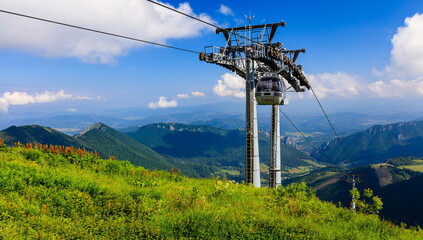 Cable car leading to a green mountain ridge. Vratna dolina. © Radek Vicar
