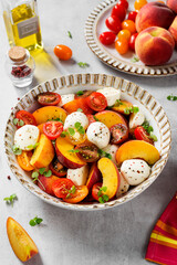 Summer peach Caprese salad with mozzarella and cherry tomatoes.