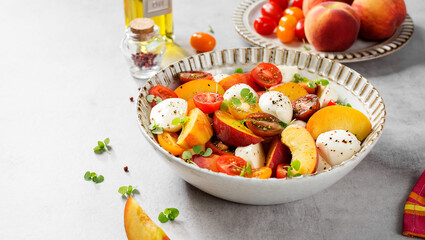 Summer peach Caprese salad with mozzarella and cherry tomatoes.