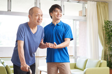 Obraz premium 高齢者の歩行介助をする介護士