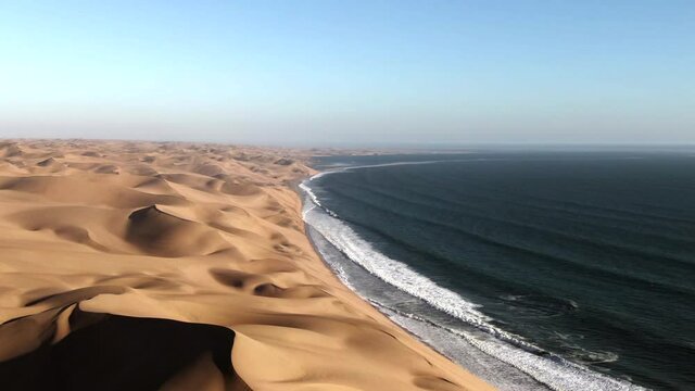 Aerial view of Sandwich Harbour, where towering sand dunes meet the Atlantic coast, near Walvis Bay in the Namib-Naukluft National Park, Namibia, Africa.
