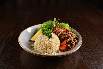 Thai style egg fried rice with spicy minced meat quorn and sliced of lemon asian vegetarian menu on wood table