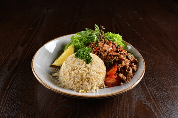 Thai style egg fried rice with spicy minced meat quorn and sliced of lemon asian vegetarian menu on wood table
