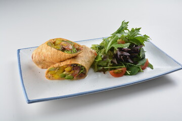 vegetarian pan tortilla wrapped with salad and dressing on white background vegan halal menu