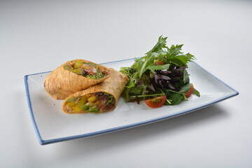 vegetarian pan tortilla wrapped with salad and dressing on white background vegan halal menu
