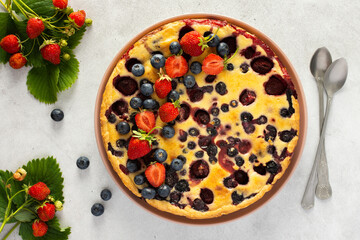 Strawberry blueberry pie decorated with fresh berries on a gray background, top view