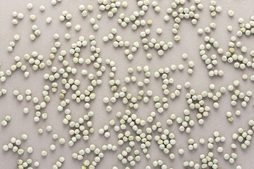 Legumes are scattered in the background, natural background of green peas, top view