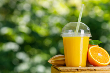 disposable plastic glass of cold freshly squeezed orange juice