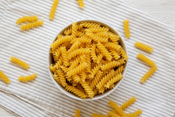 Uncooked Yellow Organic Rotini Pasta, top view. Flat lay, overhead, from above.